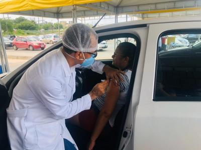 agente de saúde aplica vacina em idosa