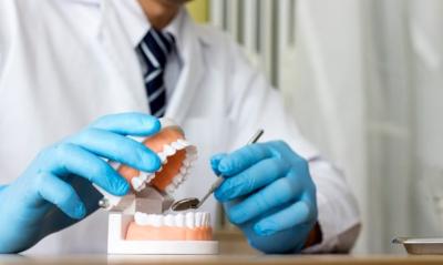 dentista analisa prótese dentária
